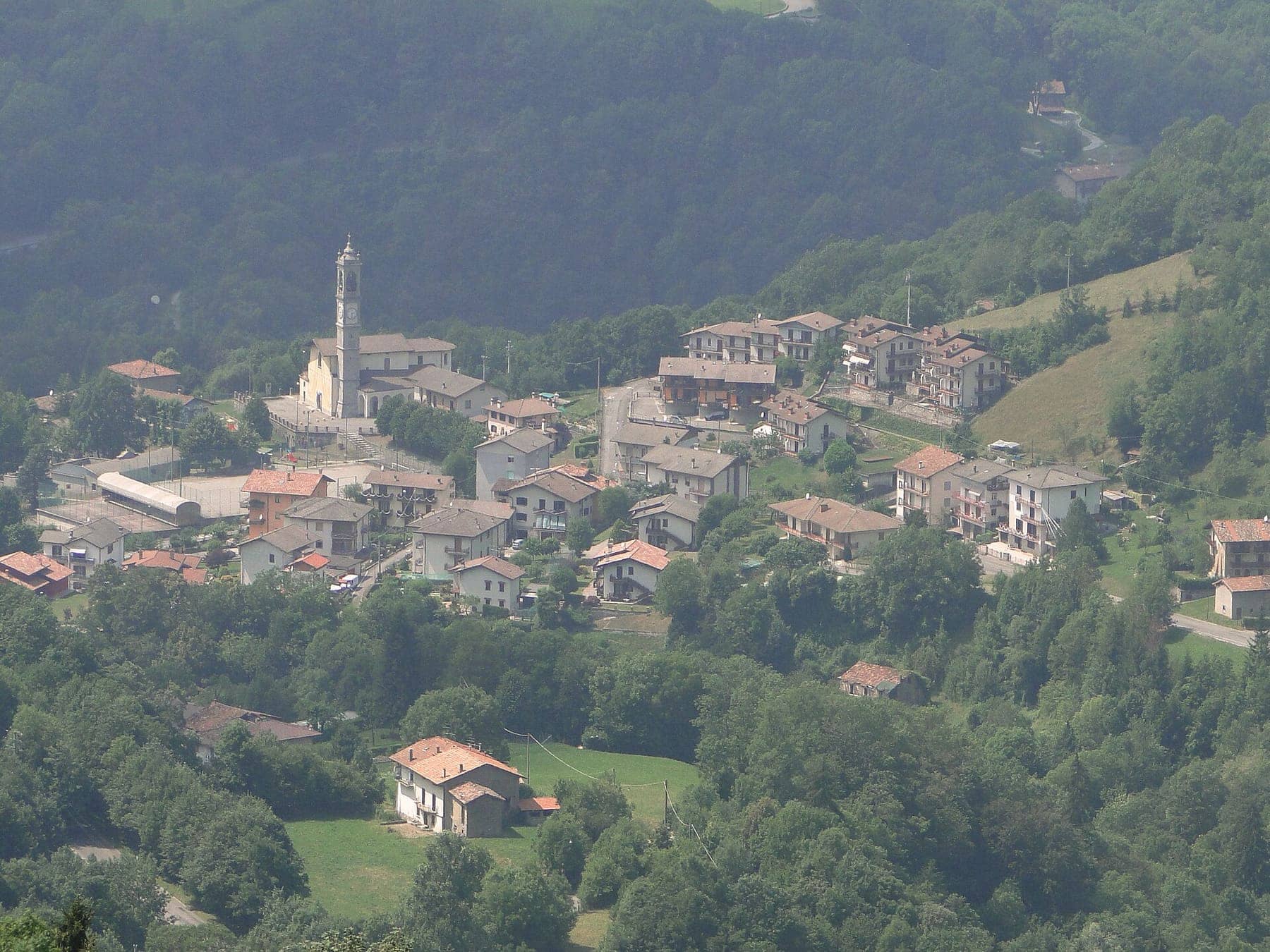 Rigosa, frazione di Algua in Val Serina, vista dall'alto: il campanile e le case tra prati e boschi