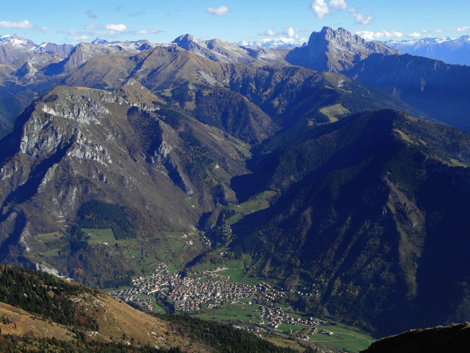 Ardesio visto dall'alto nel fondovalle dell'alta Valle Seriana, con la Presolana sullo sfondo in autunno
