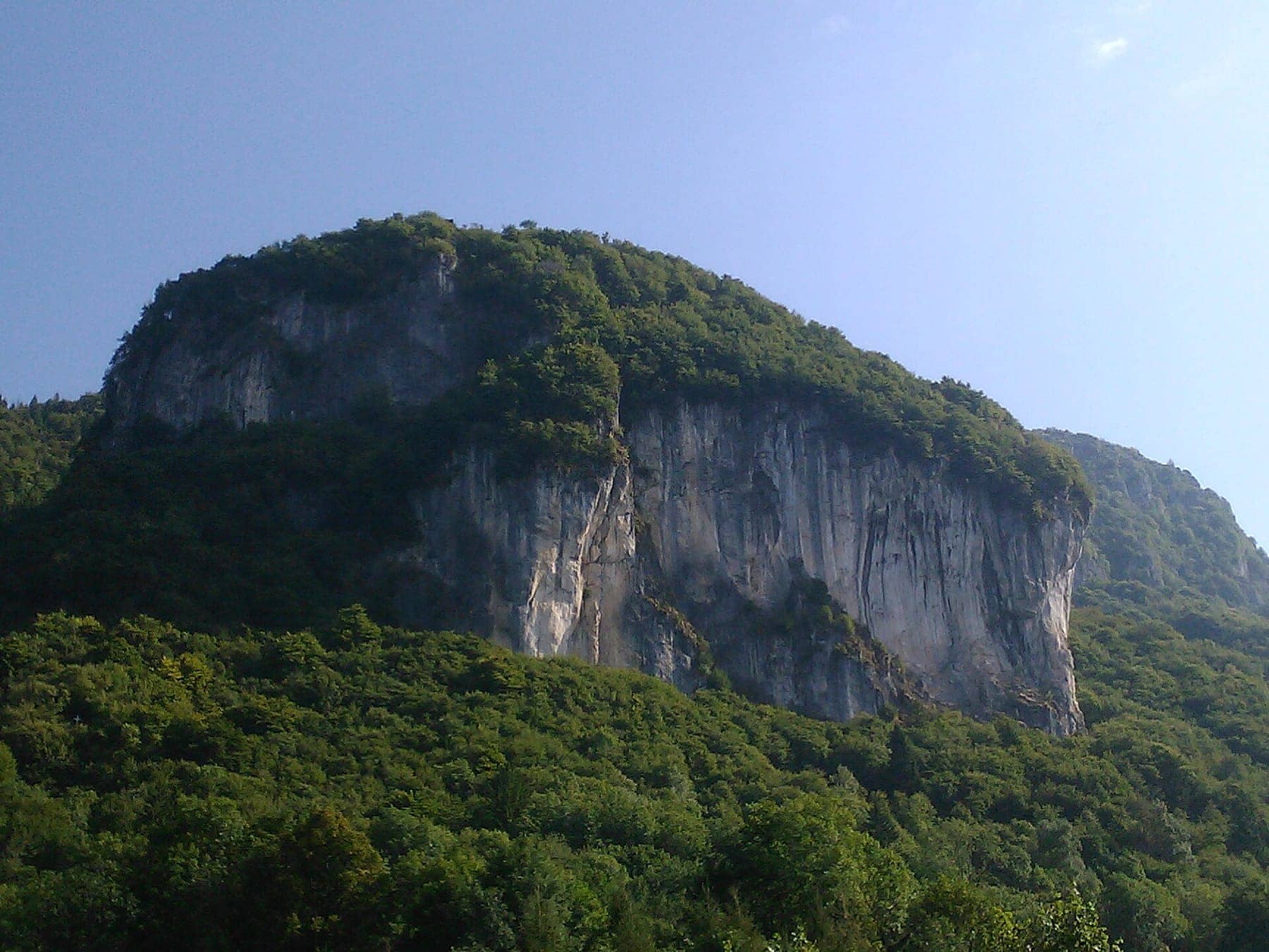 La falesia di Cornalba, grande parete calcarea per l'arrampicata che emerge dai boschi della Val Serina