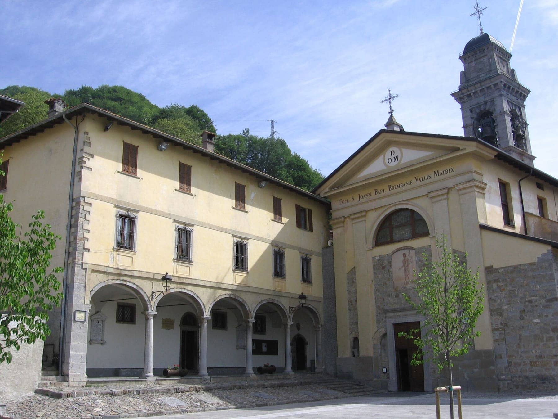 La piazza e la facciata della chiesa parrocchiale di San Giovanni Battista a Dossena, con il campanile e il porticato