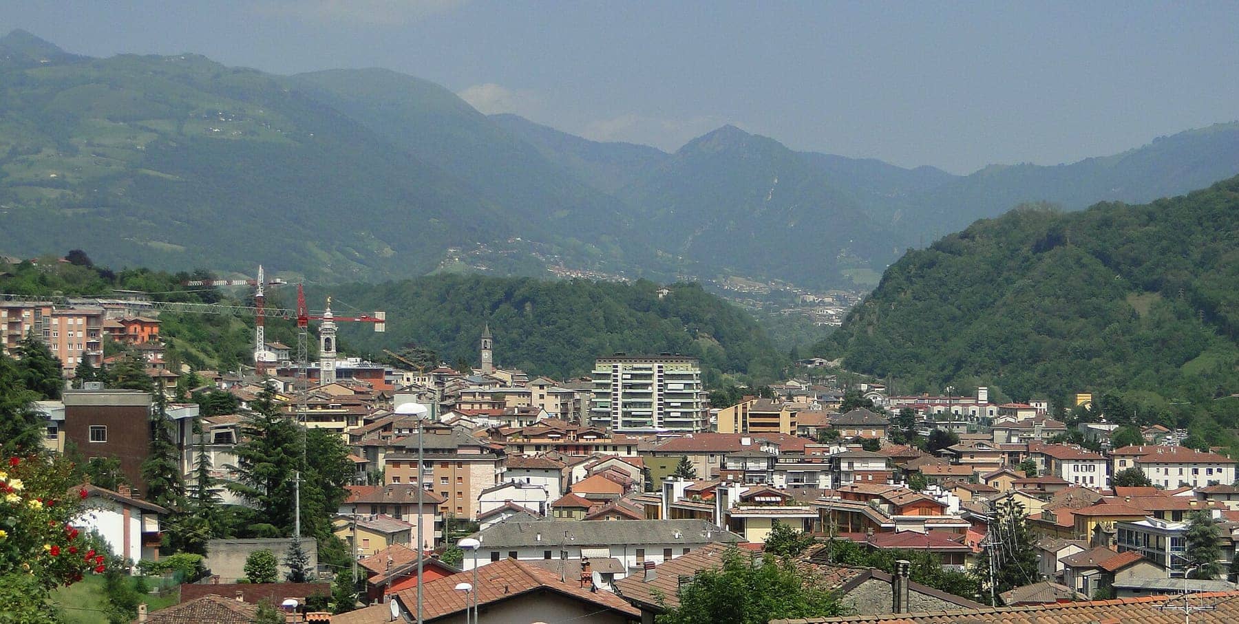 Panorama di Gazzaniga con i tetti del paese, il campanile e la Media Valle Seriana chiusa dalle montagne