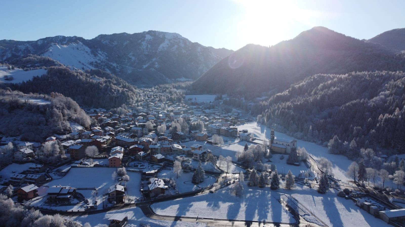 Onore visto dall'alto in inverno, con il paese innevato, la chiesa e le montagne dell'altopiano di Clusone