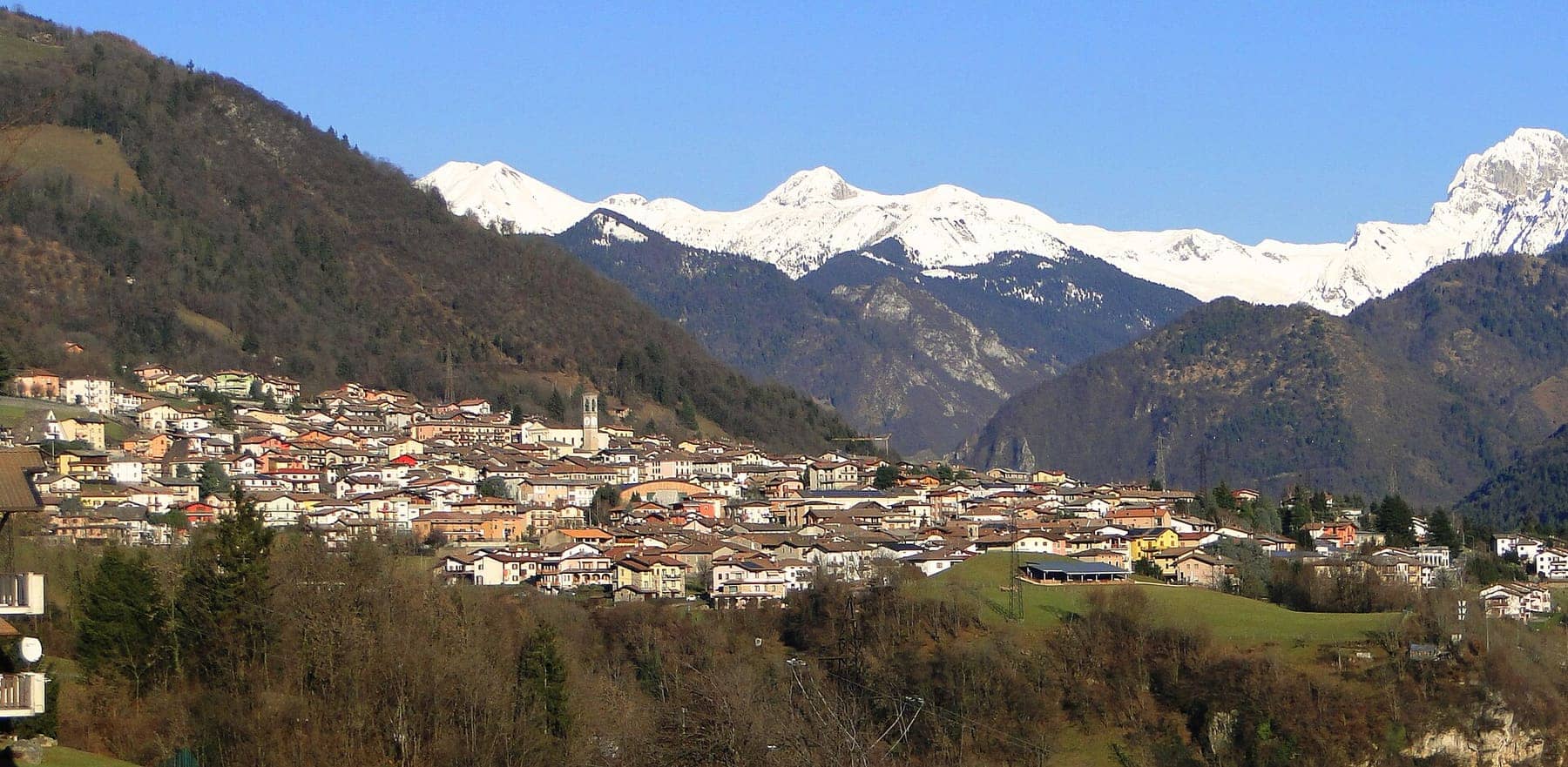 Panorama di Parre in Media Valle Seriana con il campanile al centro del paese e le Orobie innevate sullo sfondo