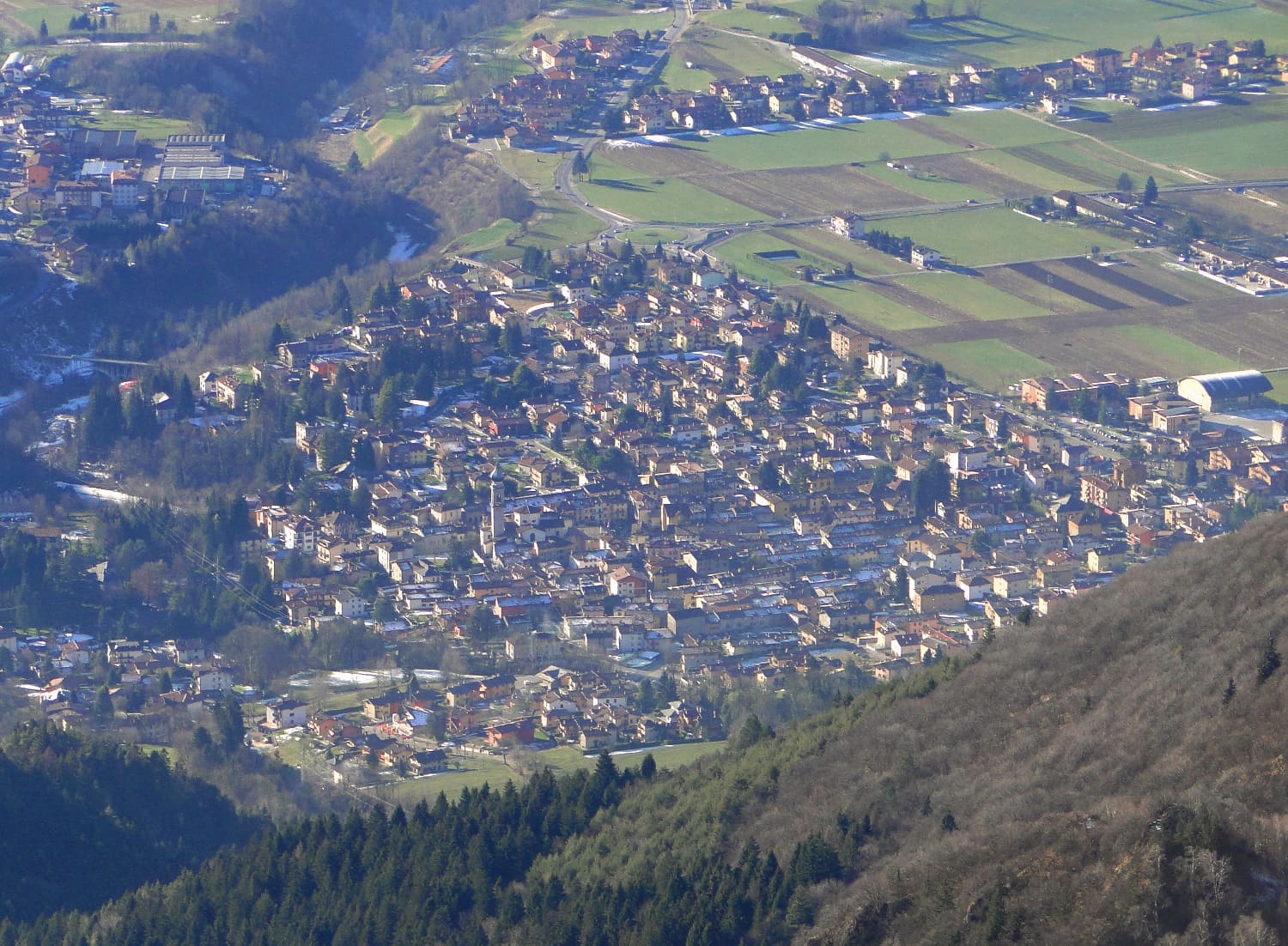 Il paese di Rovetta visto dall'alto in inverno, con i campi dell'altopiano di Clusone alle spalle