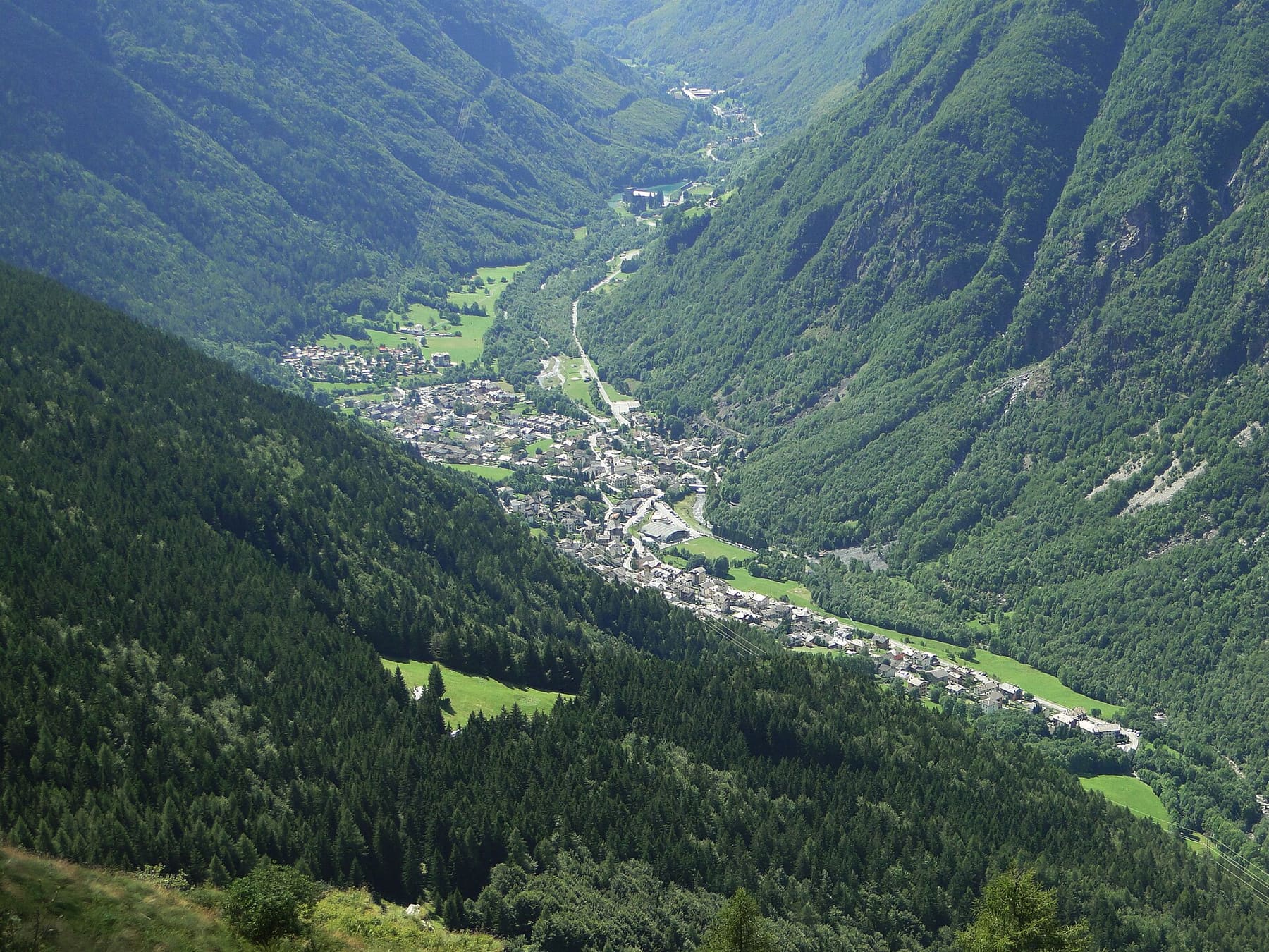 Valbondione visto dall'alto: il paese lungo il fiume Serio stretto tra i versanti boscosi dell'alta Valle Seriana