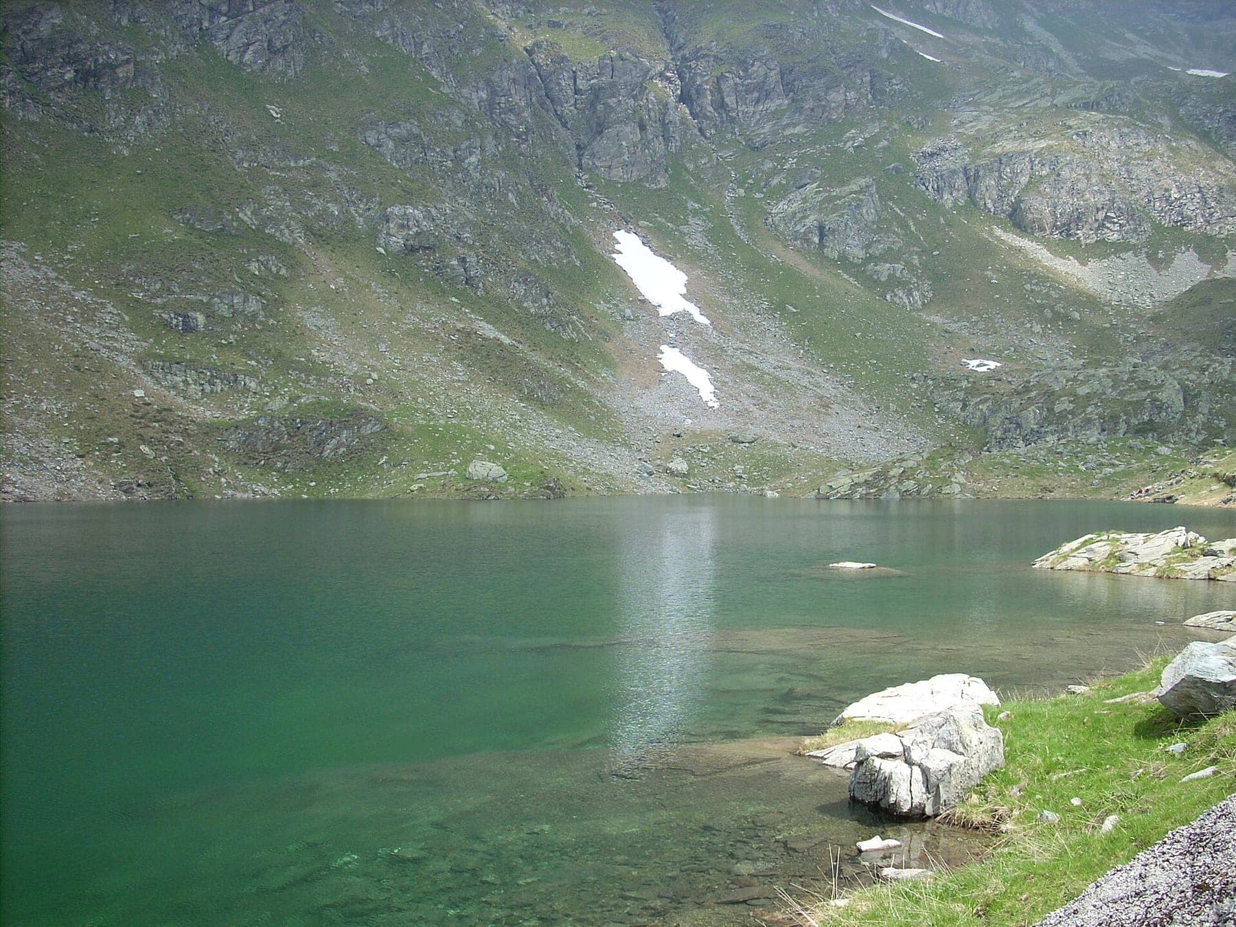 Il lago Cernello con l'acqua verde smeraldo tra i pendii rocciosi sopra Valgoglio, lungo il giro dei laghi