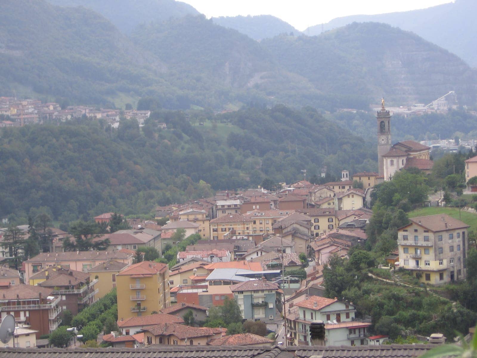 Zogno dall'alto, con il campanile della parrocchiale e i tetti del centro in media Valle Brembana