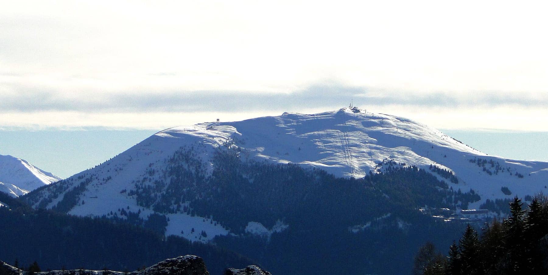 Il Monte Pora innevato con le piste da sci e gli impianti di risalita visibili sul versante, in inverno