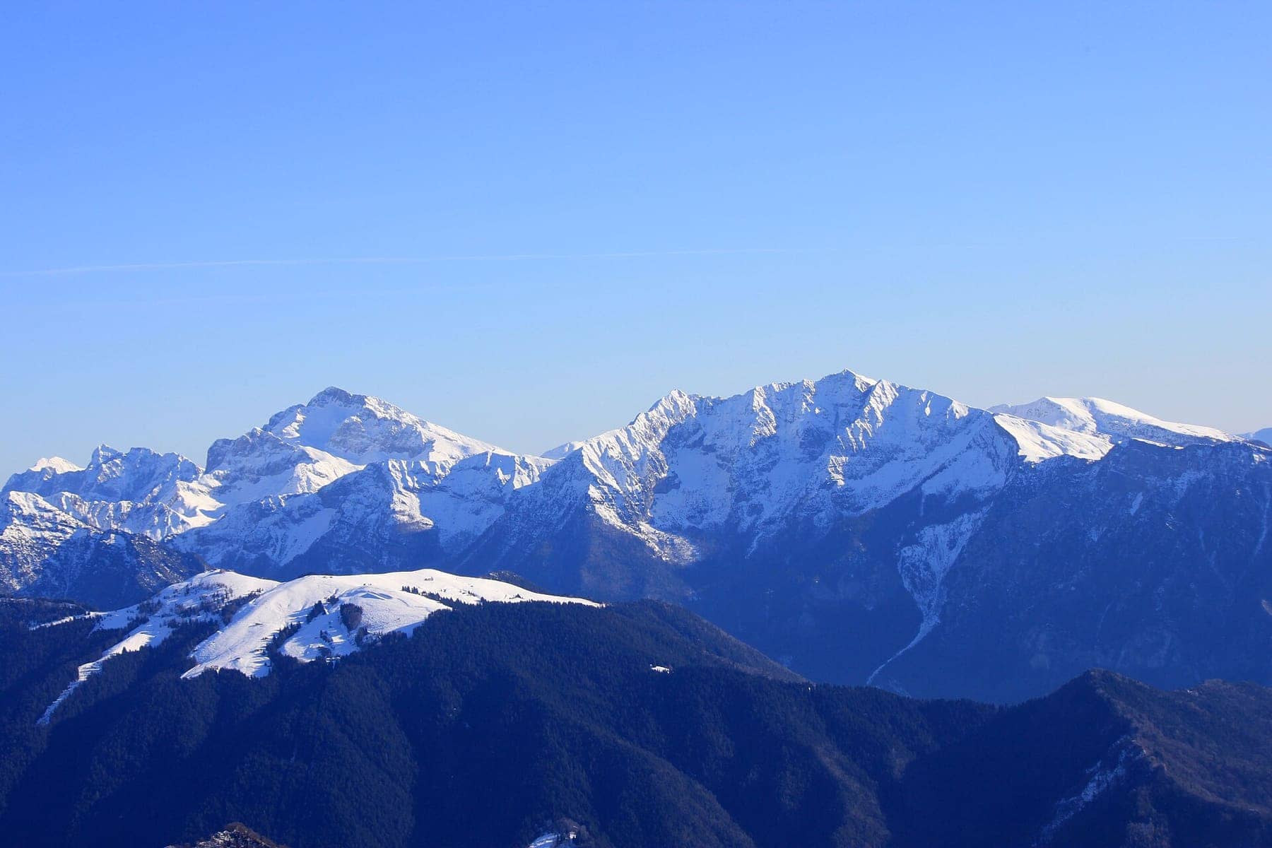 Il dosso innevato del Monte Torcola, la montagna delle piste di Piazzatorre, con la cresta del Pizzo Arera sullo sfondo in inverno